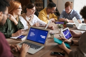 people from a startup sitting around a table on their laptops and tablets