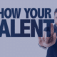 A confident temporary employee pointing to the text 'Show Your Talent' signifying the importance of showcasing skills in the workplace, aligned with Measured Ability's advice for making a lasting impression.