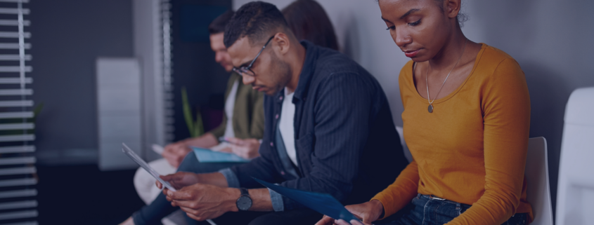 A group of South African jobseekers focused on their materials while waiting for interviews, exemplifying the proactive preparation strategies outlined in Measured Ability's guide for seasonal job applications