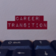 Close-up of a keyboard with a card labeled CAREER TRANSITION, symbolizing job seekers' end-of-year career change strategies