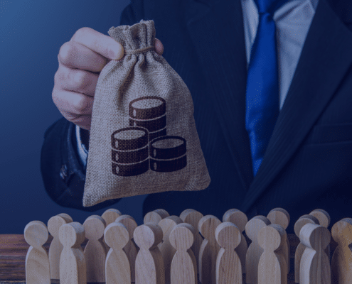 A concept image depicting a hand holding a money bag with coin stacks symbolizing budget allocation over a group of wooden figures representing staffing in startups