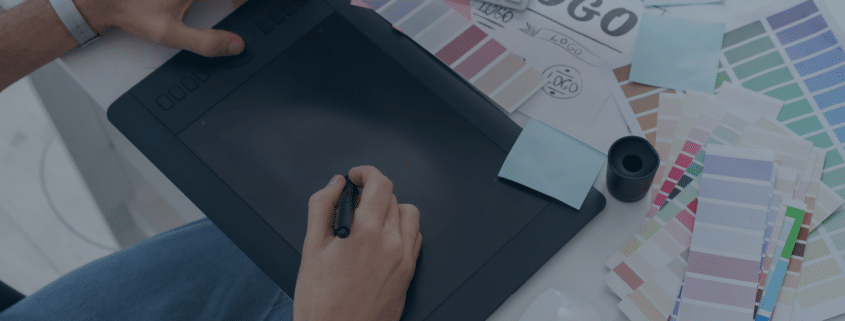 Graphic designer working with a drawing tablet and color samples, depicting the creative recruitment process in design industries.
