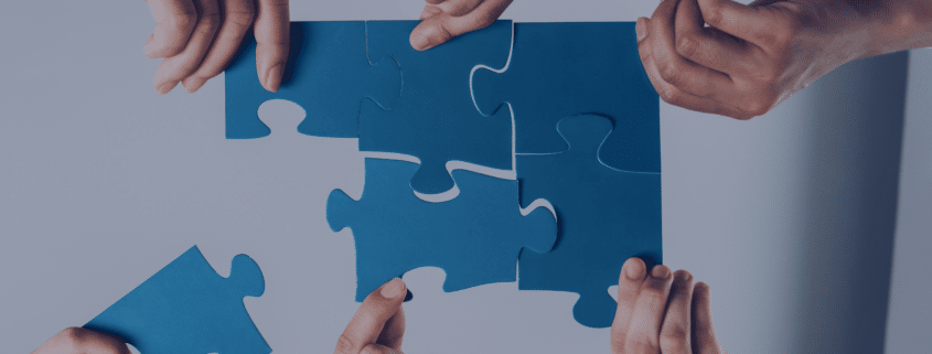Hands assembling puzzle pieces, symbolizing the integration of recruitment agencies into internal hiring processes for smooth collaboration.