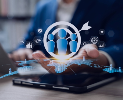 Businessperson using a tablet with recruitment and target icons hovering above, symbolizing how a recruitment agency supports H2 hiring goals