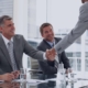 Executive candidate shaking hands with hiring panel during a leadership interview, guided by insights from a recruitment agency.