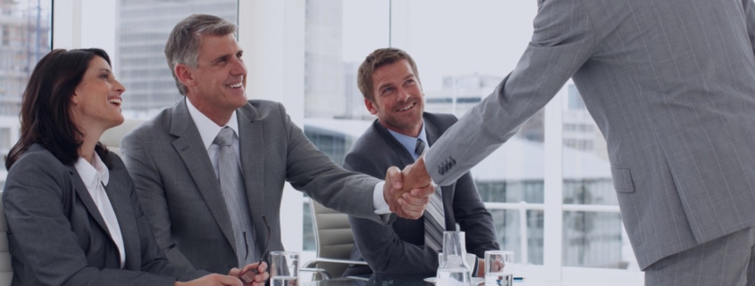Executive candidate shaking hands with hiring panel during a leadership interview, guided by insights from a recruitment agency.