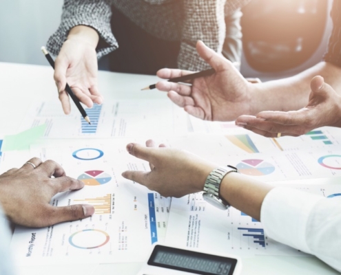 Business leaders analysing performance charts during a strategic planning session, demonstrating how a recruitment agency uses needs analysis to secure smarter executive hires.