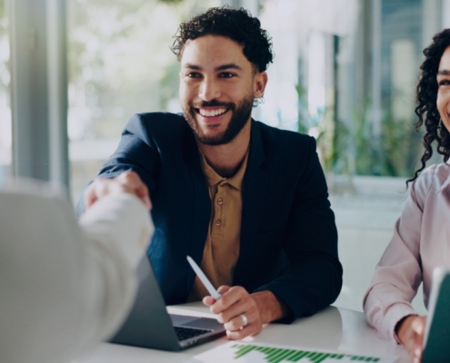 Hiring managers meeting with a candidate, illustrating how recruitment services support faster and more effective early-year hiring decisions compared to internal hiring.