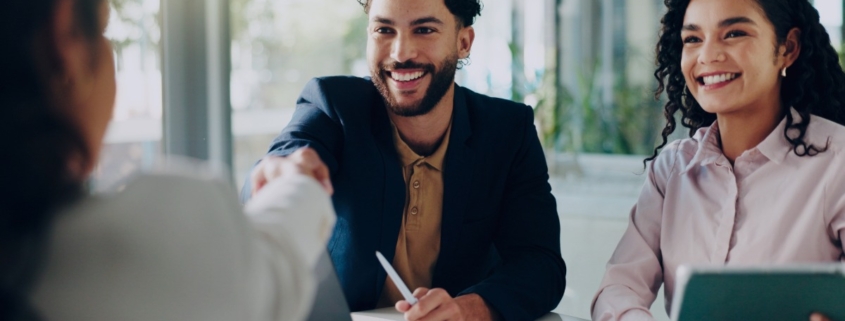 Hiring managers meeting with a candidate, illustrating how recruitment services support faster and more effective early-year hiring decisions compared to internal hiring.