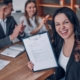 Successful job candidate holding a signed contract while colleagues applaud, highlighting how a Recruitment agency Durban connects talent with real job opportunities in Durban and KZN.