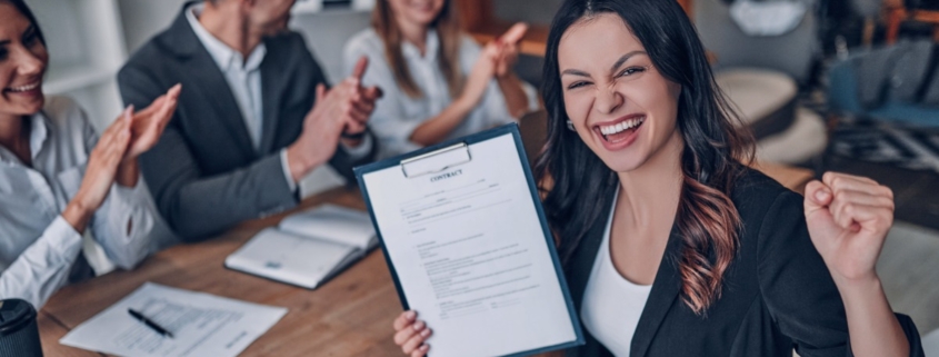 Successful job candidate holding a signed contract while colleagues applaud, highlighting how a Recruitment agency Durban connects talent with real job opportunities in Durban and KZN.