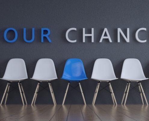 Recruitment services in Port Elizabeth helping job seekers find real opportunities in Gqeberha in 2026, shown with a blue chair standing out among white chairs.