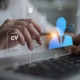 Person using a laptop with digital CV documents and candidate profile icons, representing transferable skills after job loss and new career opportunities in South Africa.